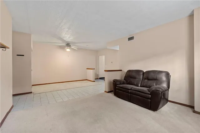 a living room with furniture and a ceiling fan