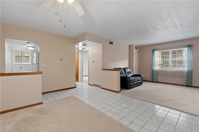 an empty room with windows and ceiling fan