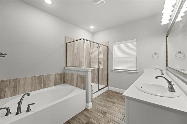 a bathroom with a tub sink and mirror