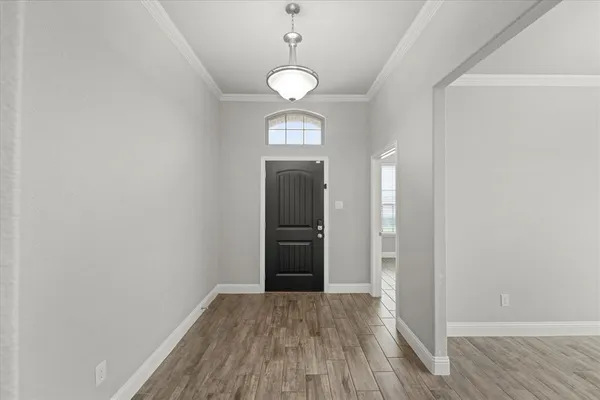 a view of empty room with wooden floor and window