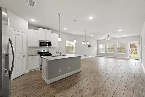 a kitchen with stainless steel appliances kitchen island wooden cabinets and white appliances