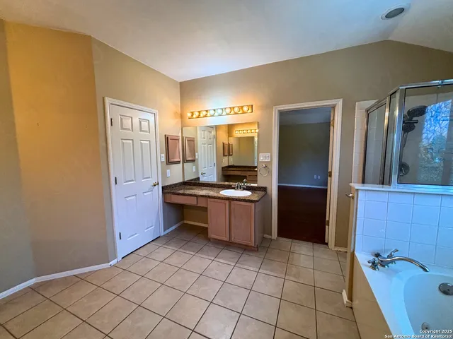 a large bathroom with a sink a mirror and a bathtub