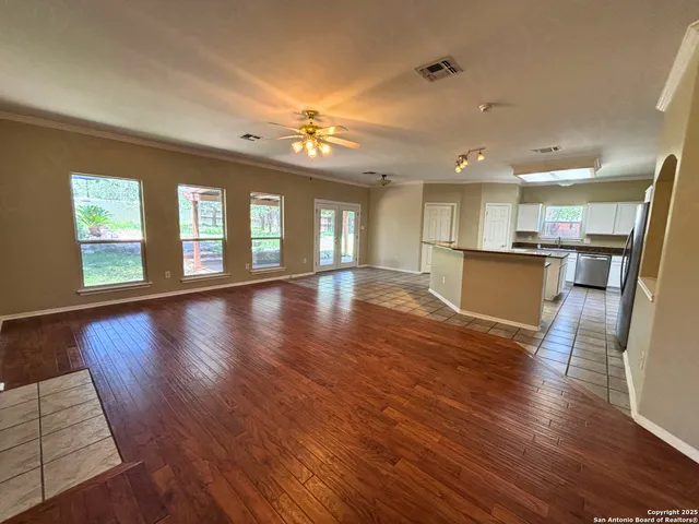 a view of a living room and kitchen with furniture wooden floor and windows