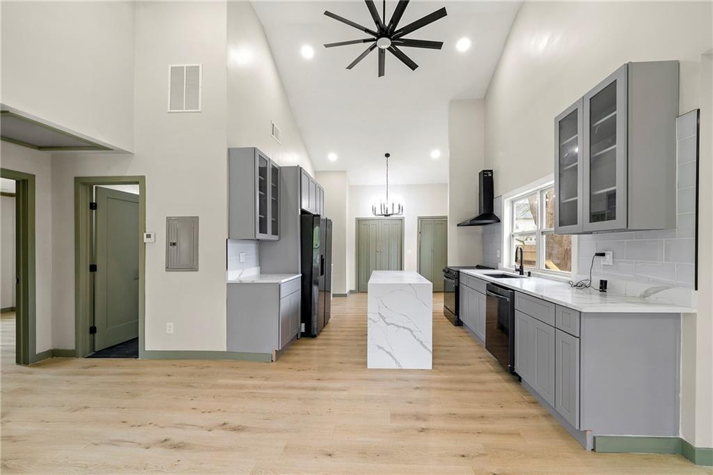 a large kitchen with stainless steel appliances a sink dishwasher stove refrigerator and cabinets