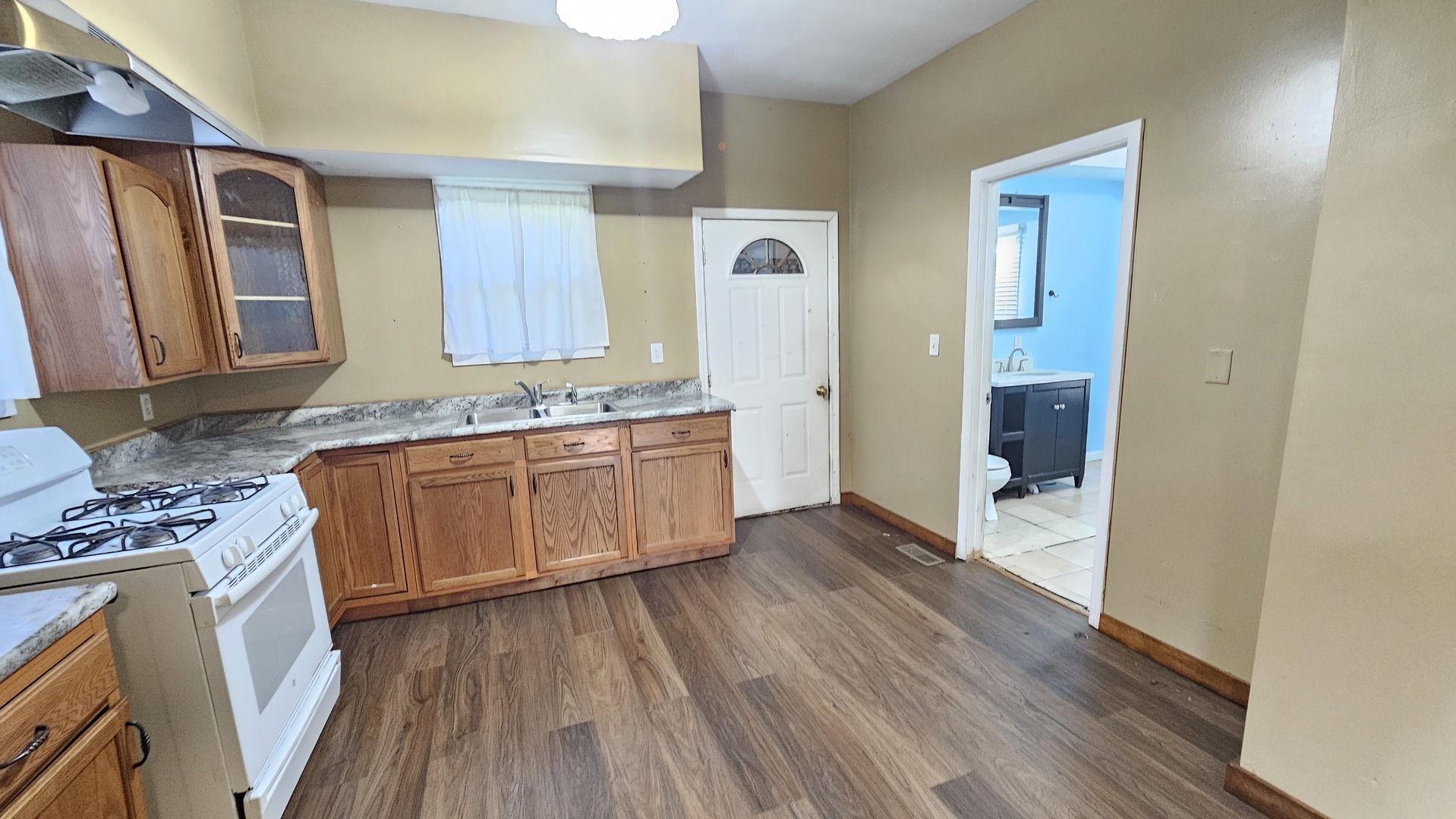 426 North Hebbard Street Joliet, IL 60432 - Photo 19 of 42 a kitchen with stainless steel appliances granite countertop a stove a sink and a refrigerator with wooden floors