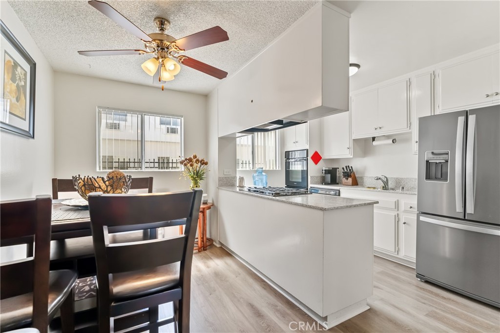 4641 Arlington Avenue Riverside, CA 92504 - Photo 16 of 33 a kitchen with stainless steel appliances granite countertop a dining table chairs refrigerator and sink