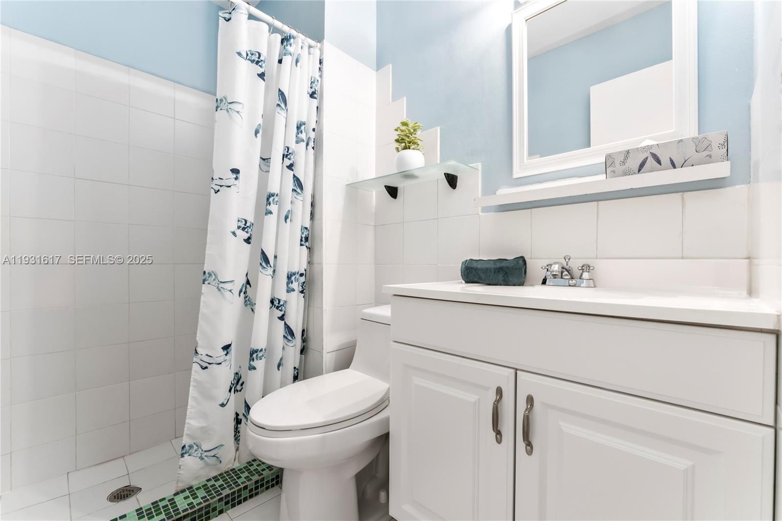 9612 Wyoming Court Boca Raton, FL 33434 - Photo 23 of 44 a bathroom with a sink a toilet and shower curtain