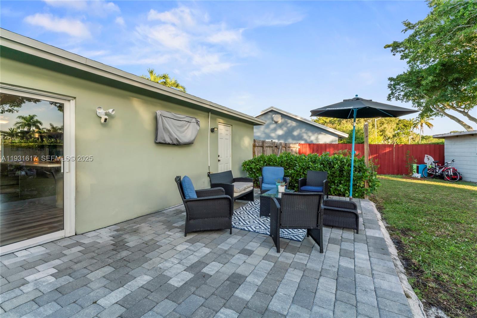 9612 Wyoming Court Boca Raton, FL 33434 - Photo 28 of 44 a patio with a table and chairs under an umbrella