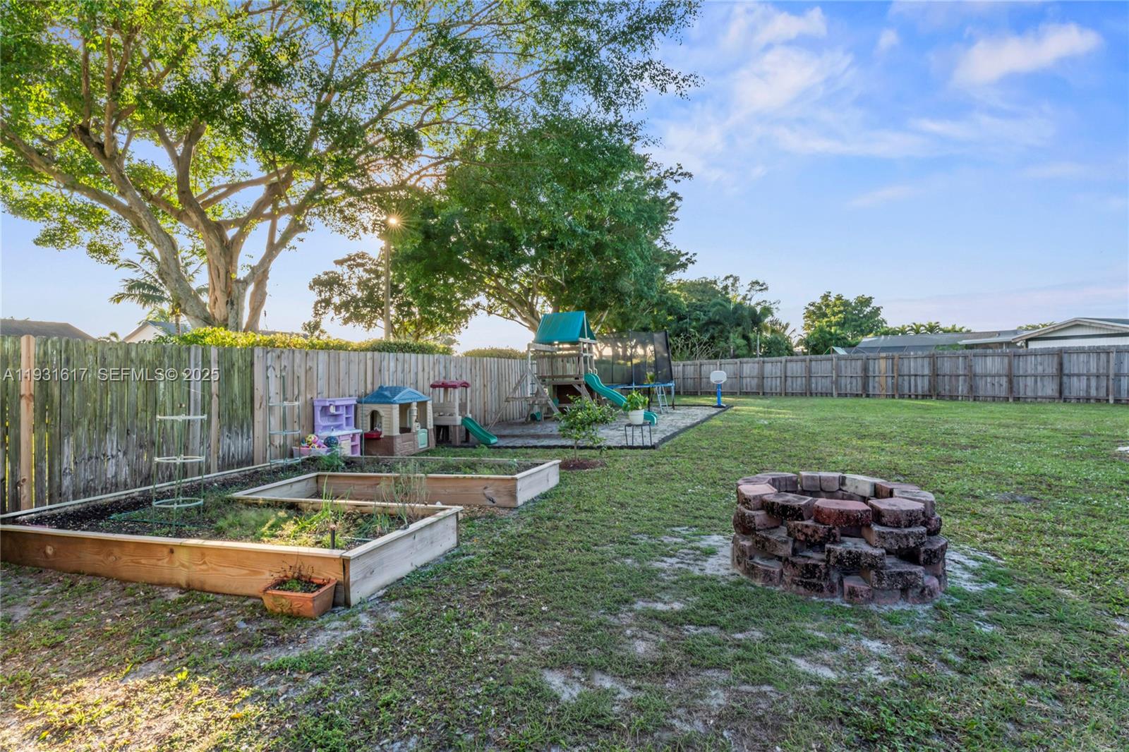 9612 Wyoming Court Boca Raton, FL 33434 - Photo 32 of 44 a view of a backyard with table and chairs a fire pit and a big yard