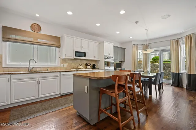 a kitchen with a table chairs sink microwave and cabinets