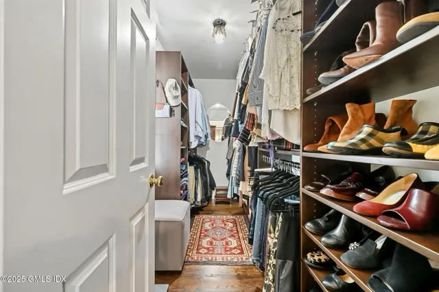 a view of walk in closet with clothes and shoes