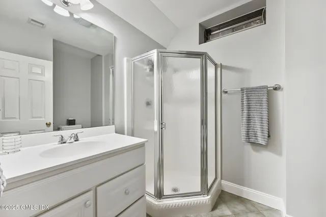 a bathroom with a sink mirror and shower