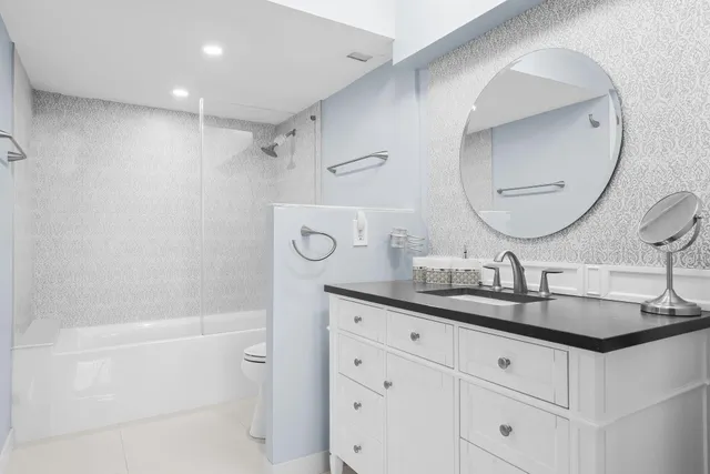 a bathroom with a double vanity sink mirror and shower
