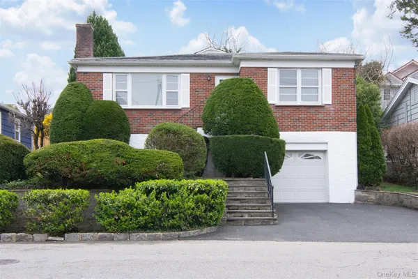 a front view of a house with a garden