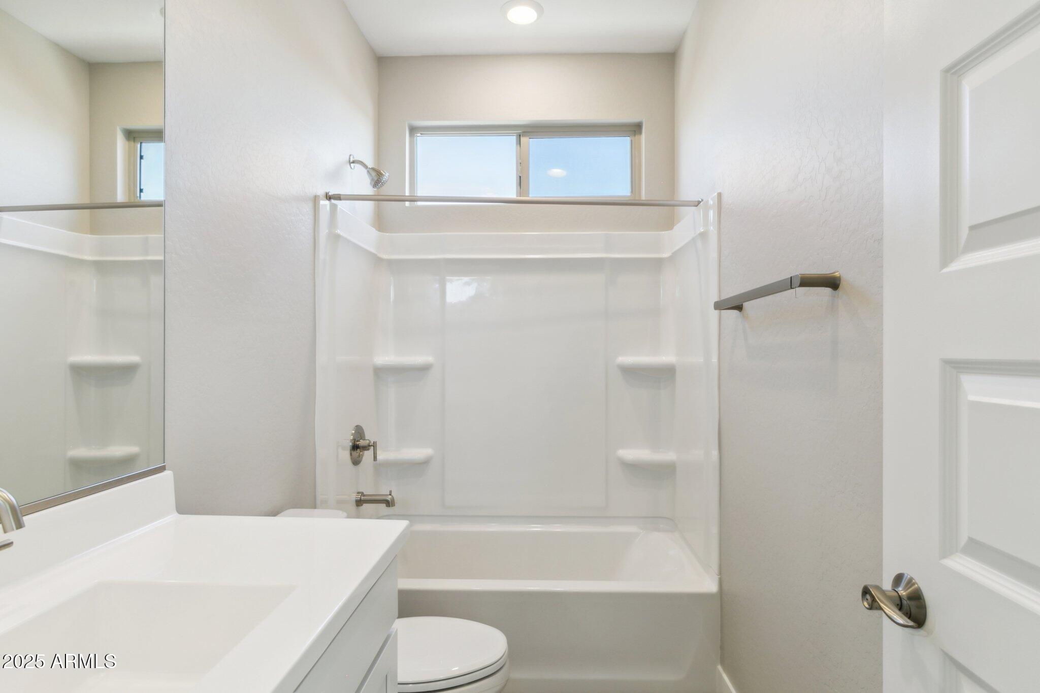 14742 West Soft Wind Drive Surprise, AZ 85387 - Photo 17 of 26 a bathroom with a bathtub shower sink vanity and toilet