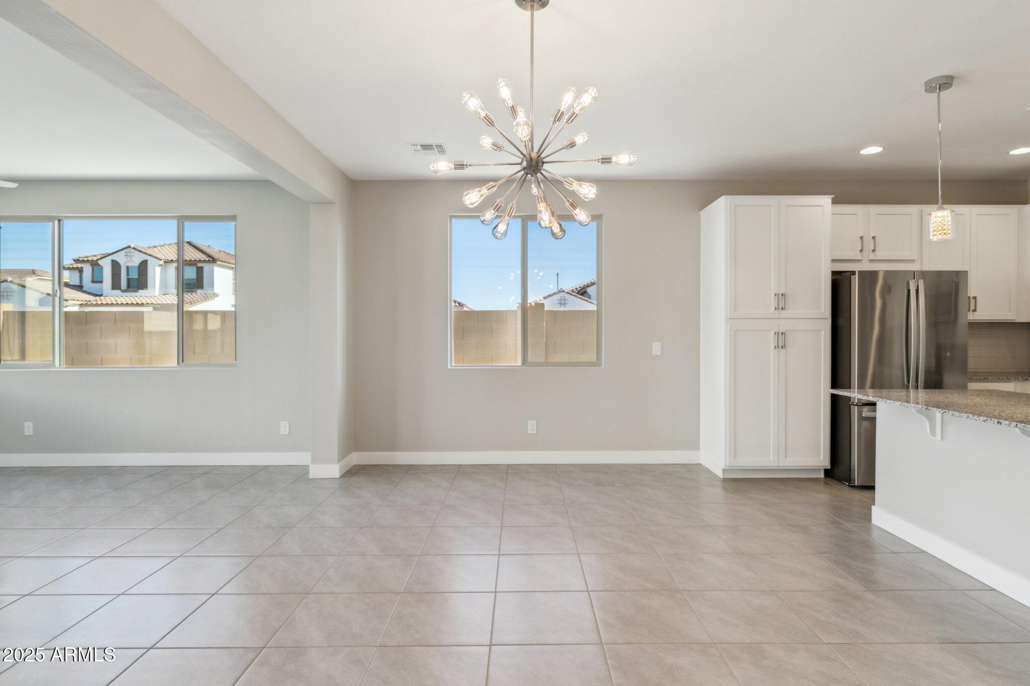 14742 West Soft Wind Drive Surprise, AZ 85387 - Photo 6 of 26 a view of an empty room with window and kitchen view