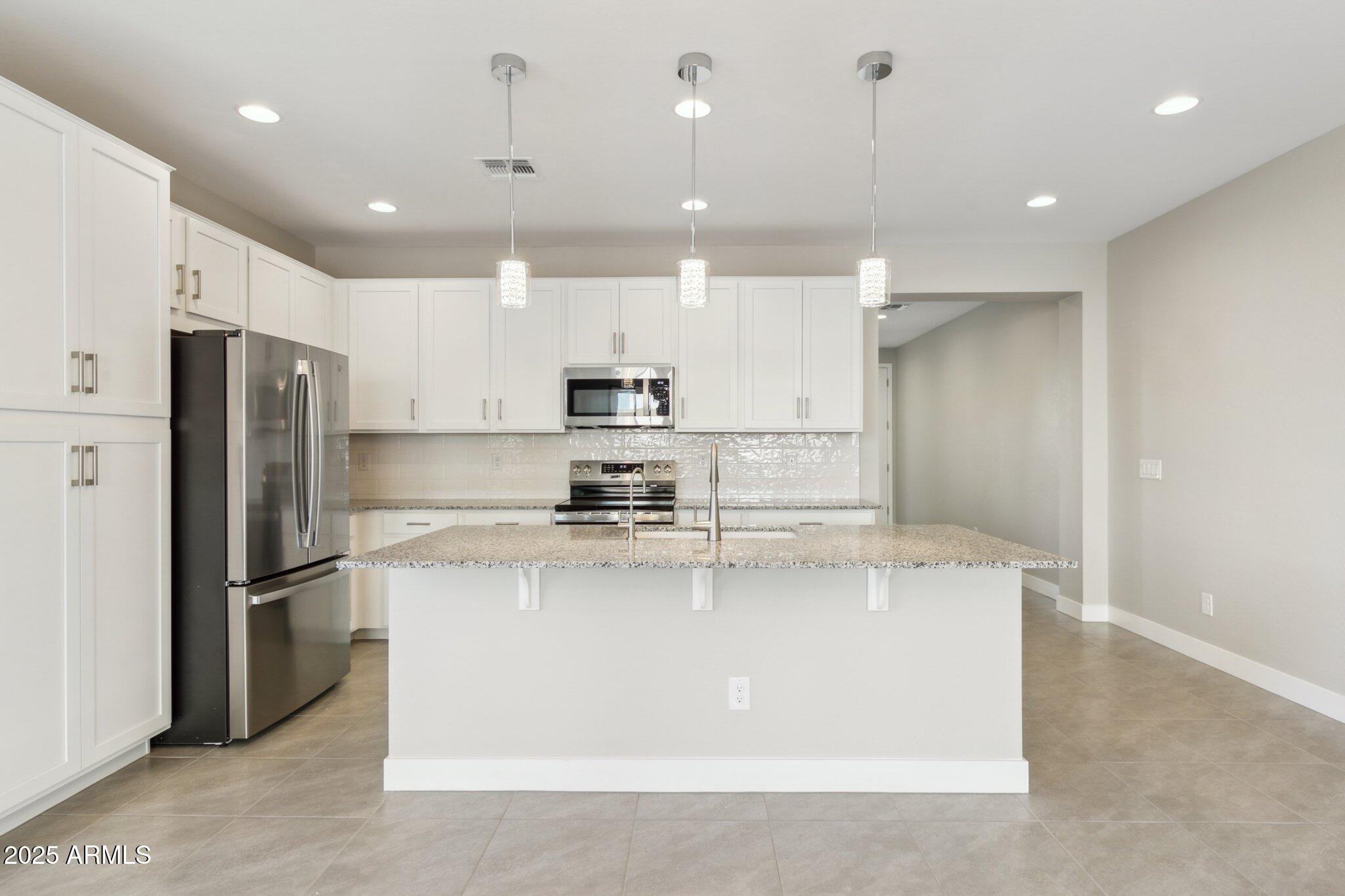 14742 West Soft Wind Drive Surprise, AZ 85387 - Photo 9 of 26 a kitchen with stainless steel appliances granite countertop a refrigerator a stove a sink and a refrigerator