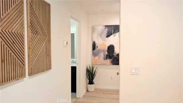 a view of a hallway with wooden floor and a potted plant