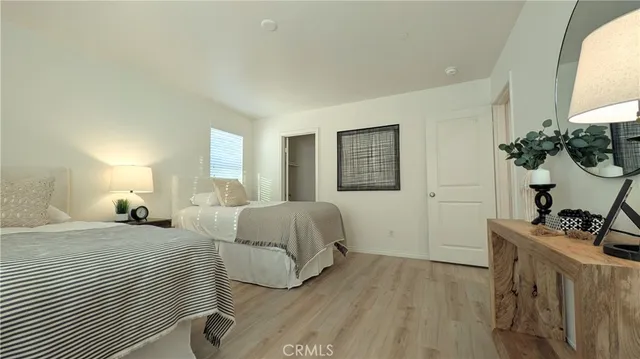 a bedroom with a bed and a dresser with mirror