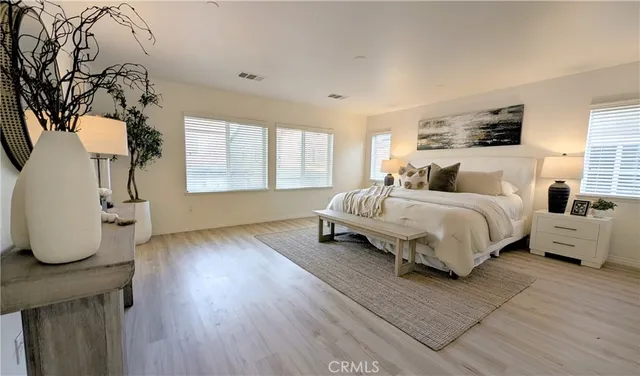 a spacious bedroom with a bed a couch and large windows