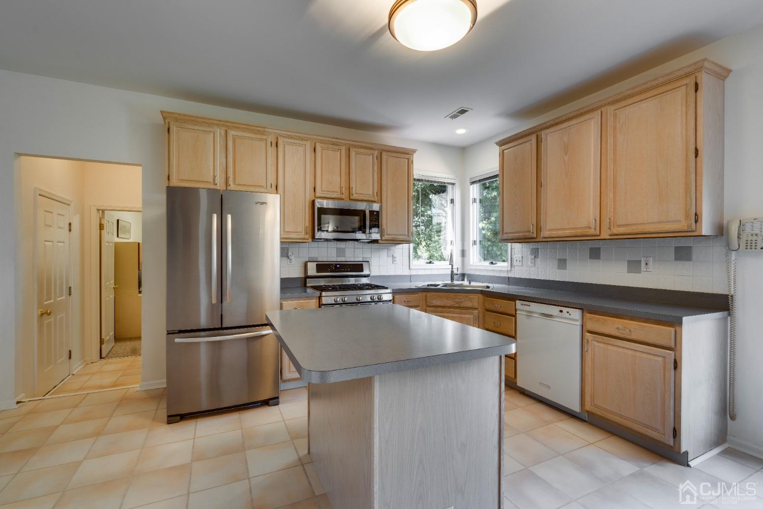 9 Dickinson Road Kendall Park, NJ 08824 - Photo 10 of 34 a kitchen with granite countertop a refrigerator a sink a stove top oven and cabinetry