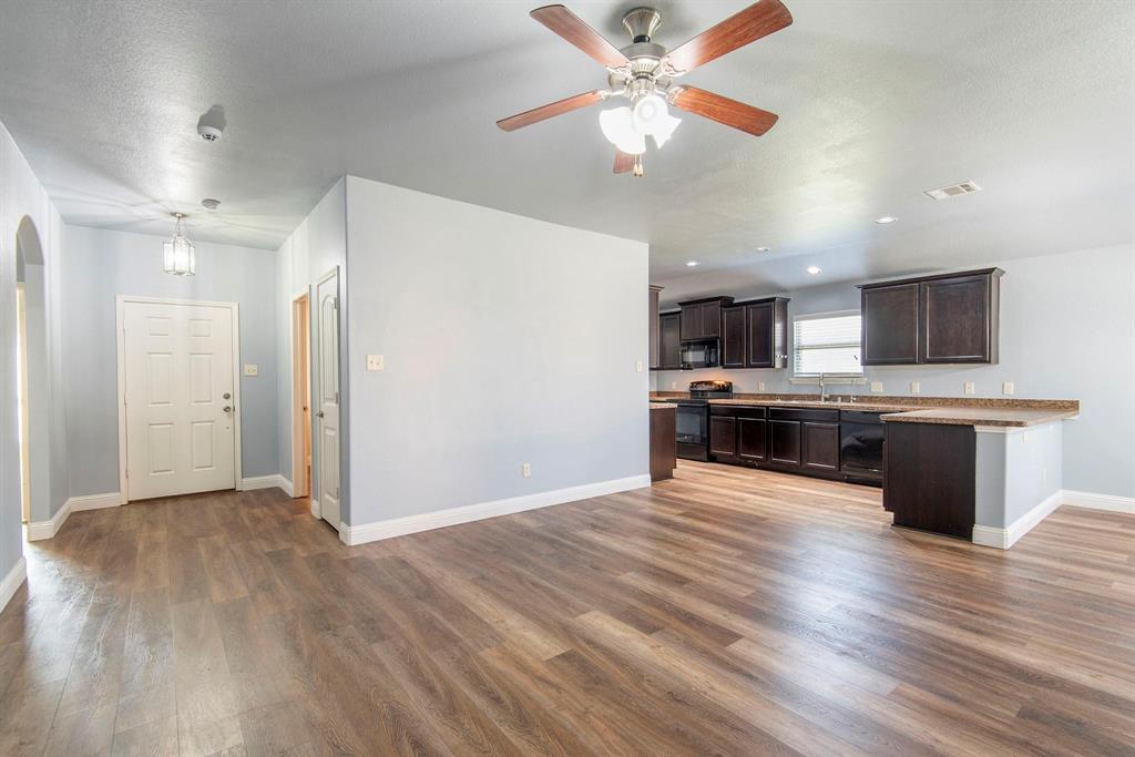 1813 Rodeo Drive Anna, TX 75409 - Photo 4 of 6 Unfurnished living room with dark wood-style floors, arched walkways, ceiling fan, and recessed lighting