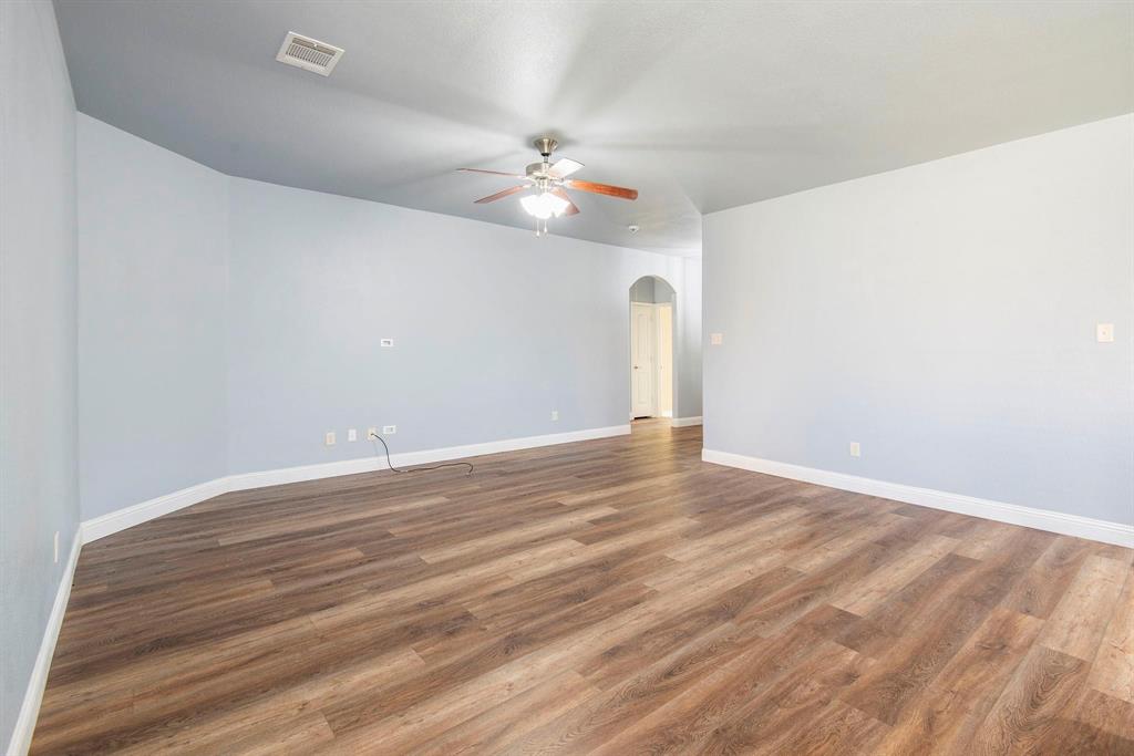 1813 Rodeo Drive Anna, TX 75409 - Photo 5 of 6 Spare room featuring arched walkways, wood finished floors, and ceiling fan