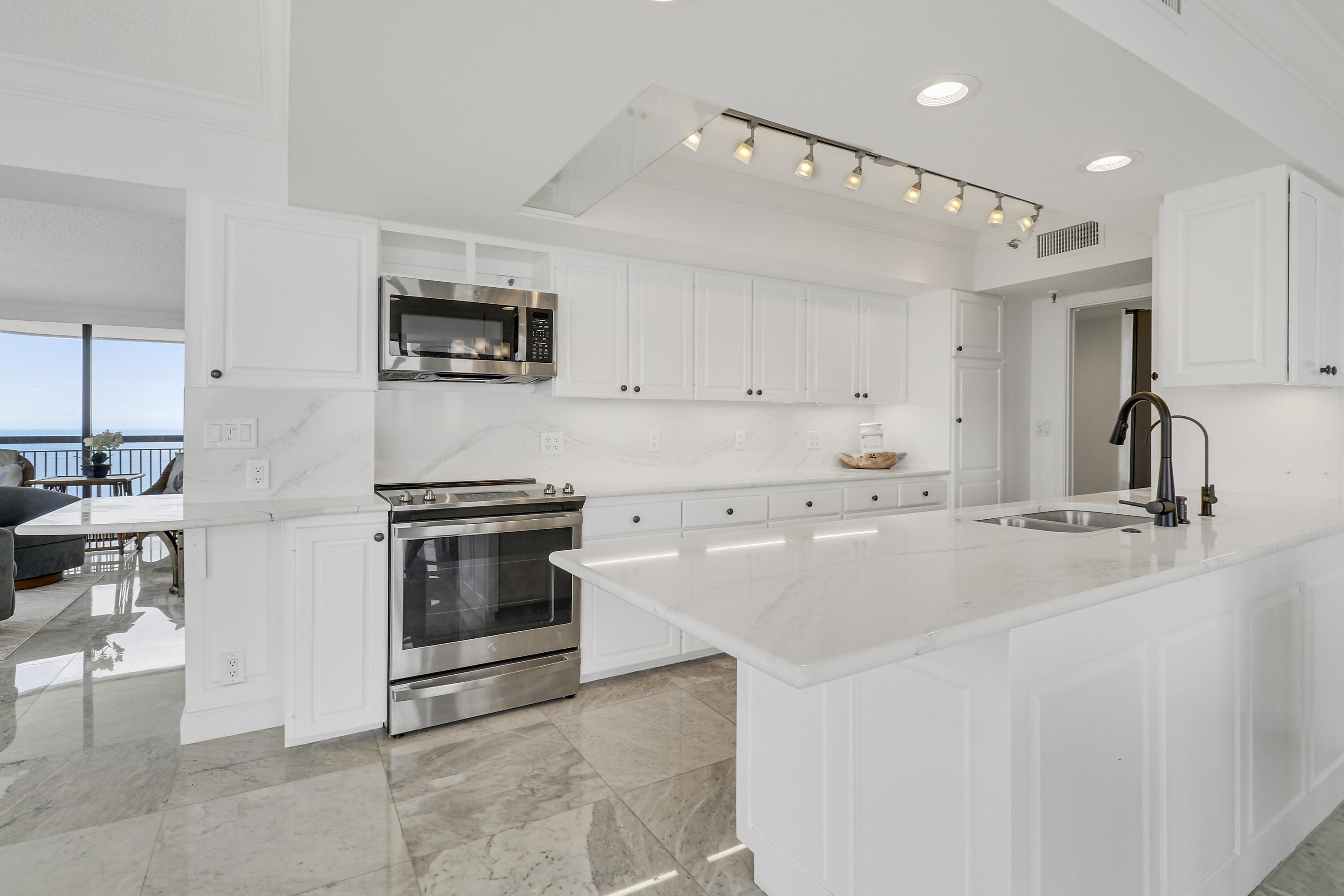 5380 North Ocean Drive, Unit 22J Riviera Beach, FL 33404 - Photo 21 of 53 a kitchen with stainless steel appliances and a stove top oven