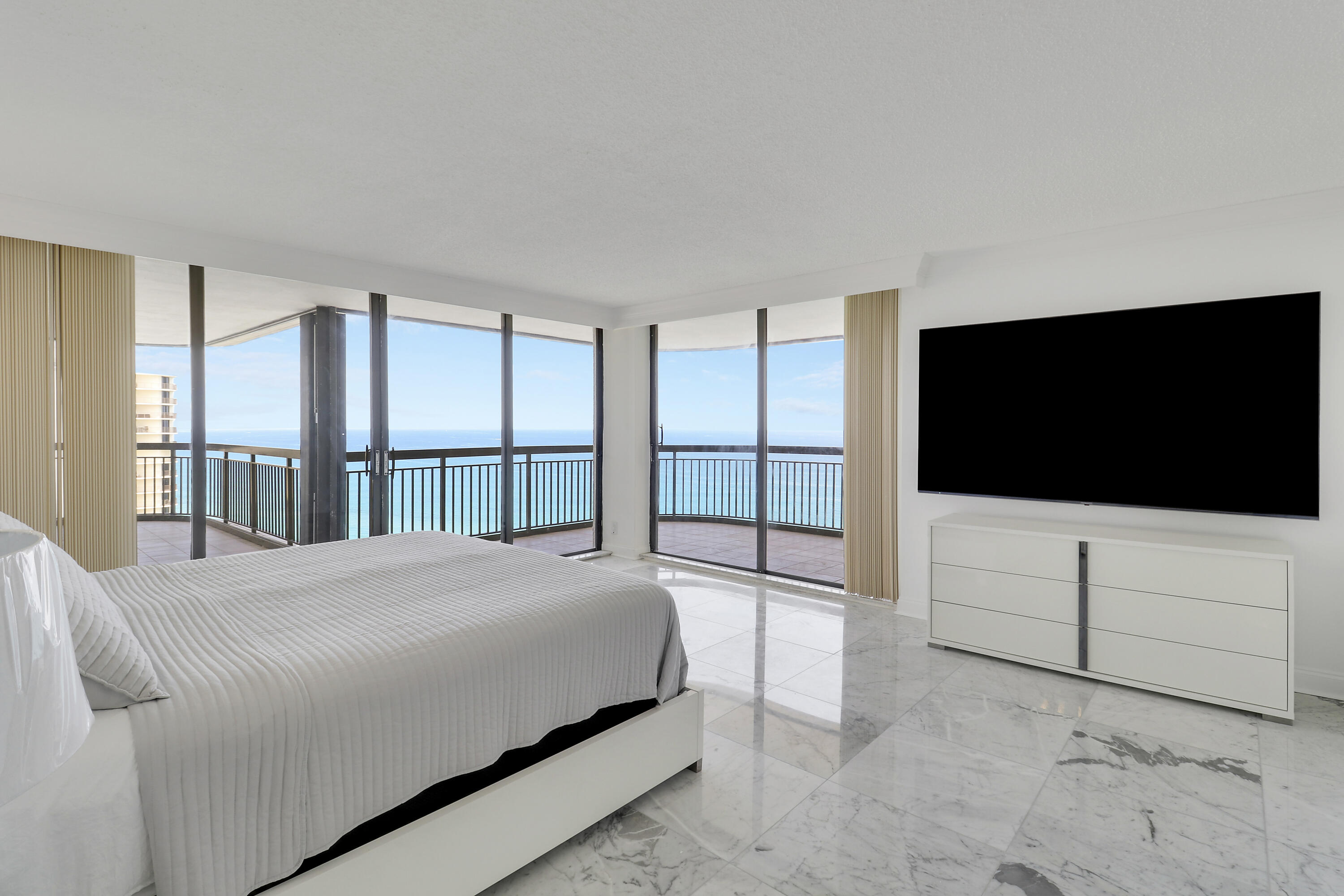5380 North Ocean Drive, Unit 22J Riviera Beach, FL 33404 - Photo 27 of 53 a bedroom with a bed tv and a large window