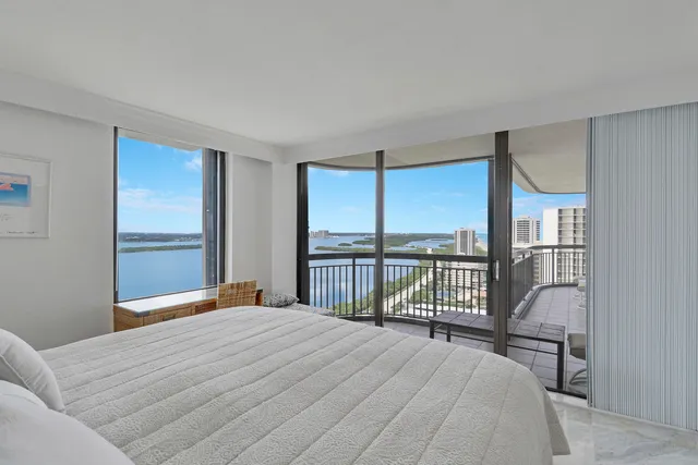 a bedroom with a bed and a large window