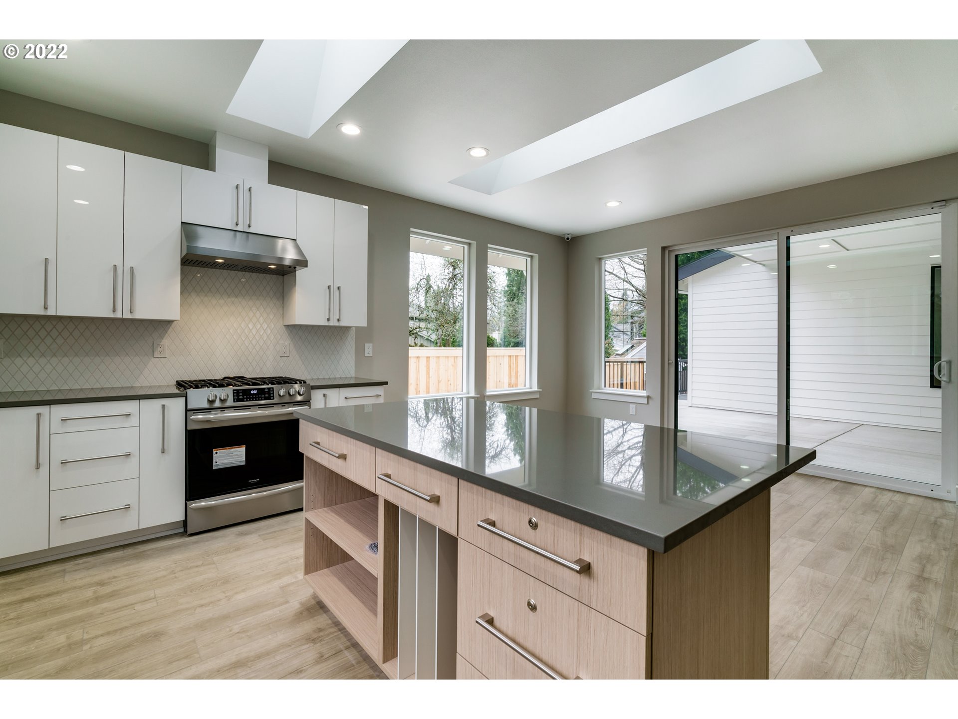7975 Southwest Oleson Road Portland, OR 97223 - Photo 11 of 32 a kitchen with stainless steel appliances granite countertop a stove a sink and a granite counter tops with white cabinets