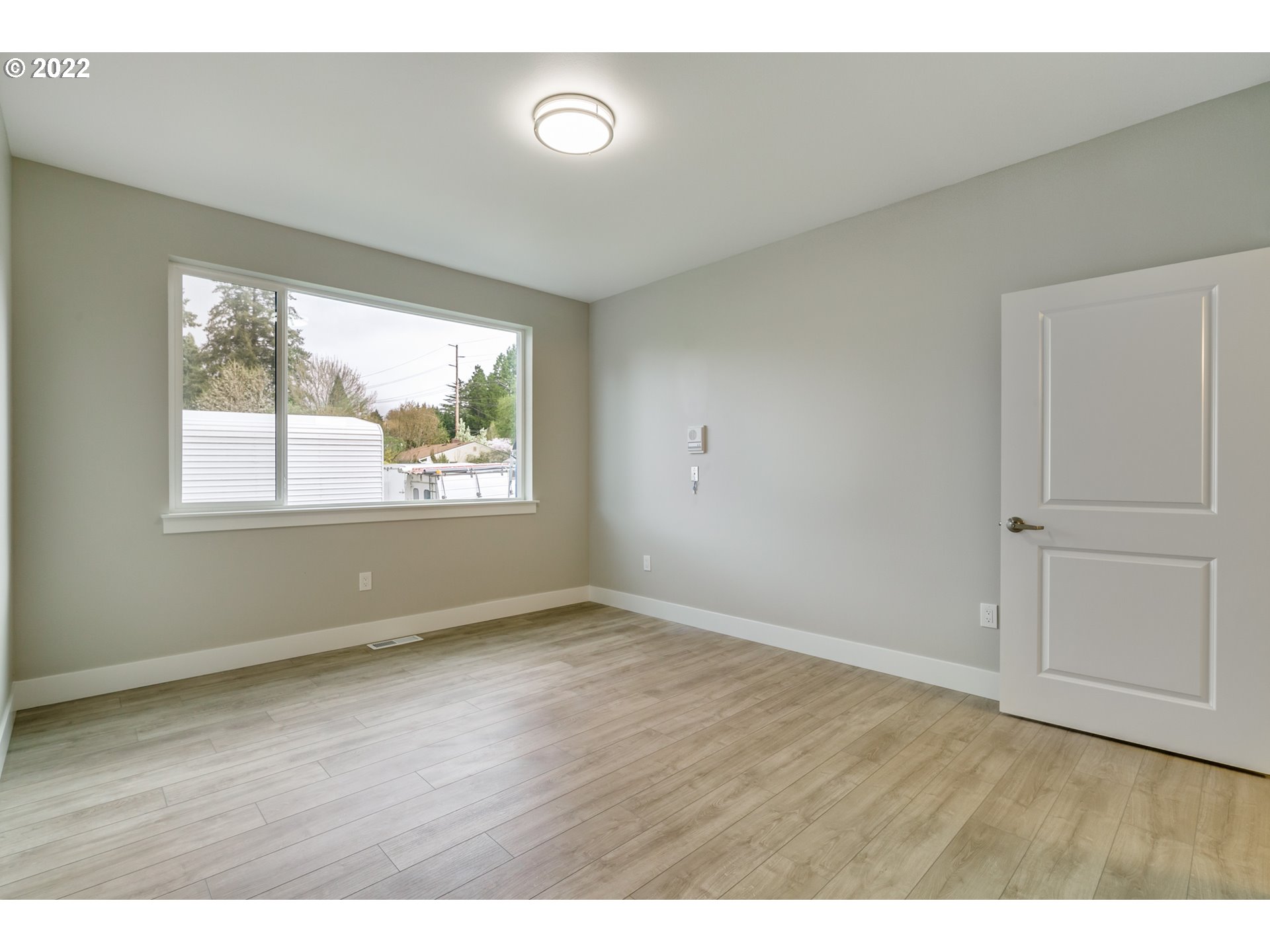 7975 Southwest Oleson Road Portland, OR 97223 - Photo 18 of 32 a view of an empty room with wooden floor and a window