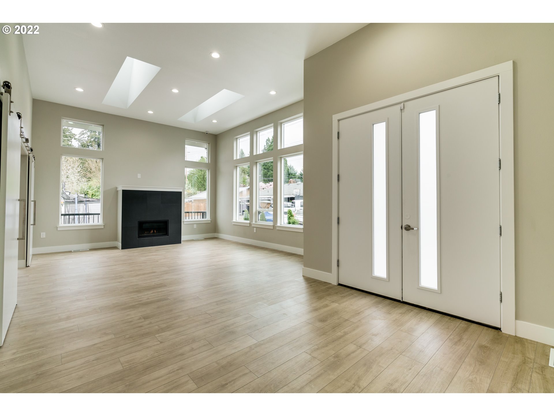 7975 Southwest Oleson Road Portland, OR 97223 - Photo 3 of 32 an empty room with wooden floor and windows
