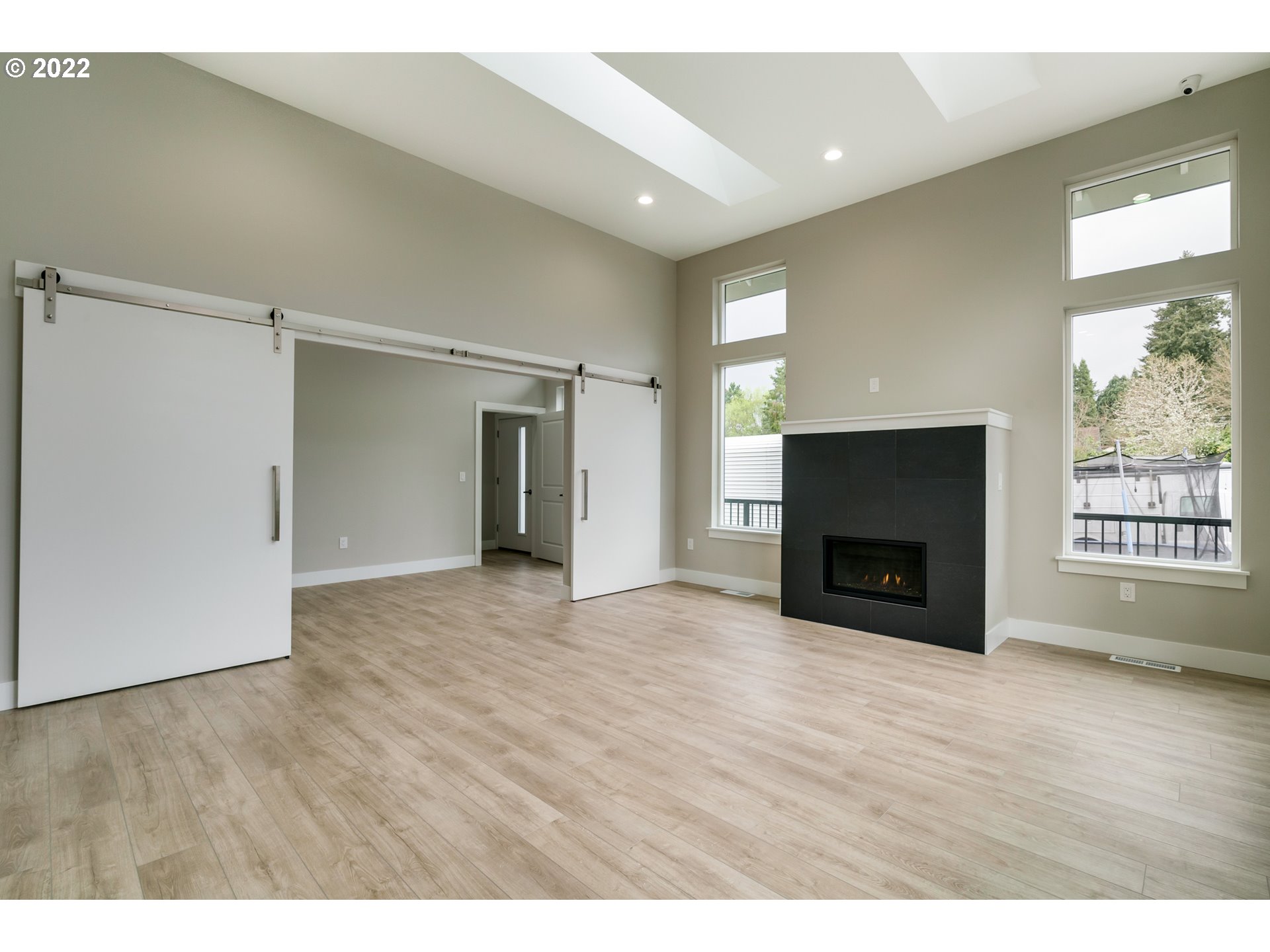 7975 Southwest Oleson Road Portland, OR 97223 - Photo 4 of 32 a view of empty room with wooden floor and fireplace