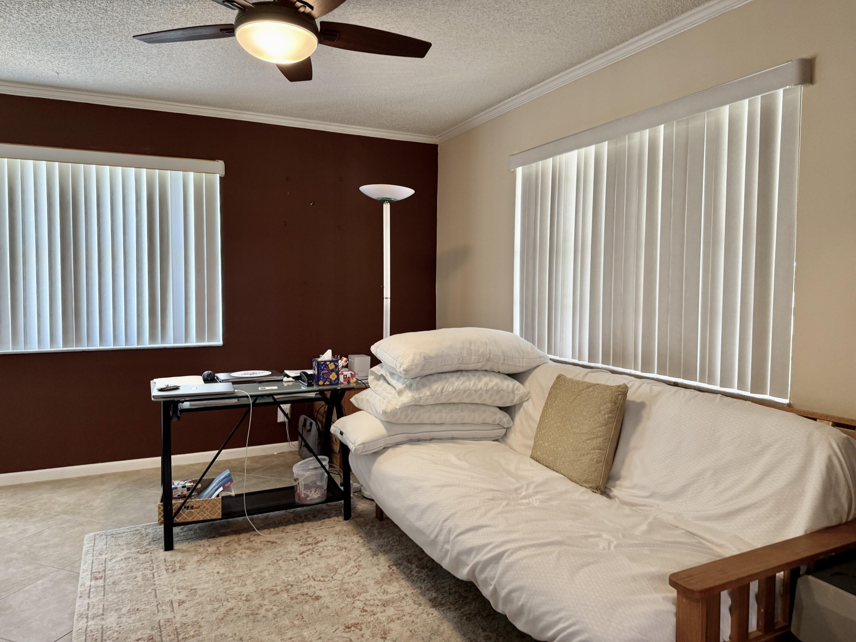 1710 Northwest 18th Avenue, Unit 204 Delray Beach, FL 33445 - Photo 11 of 21 a living room with a bed furniture and a window