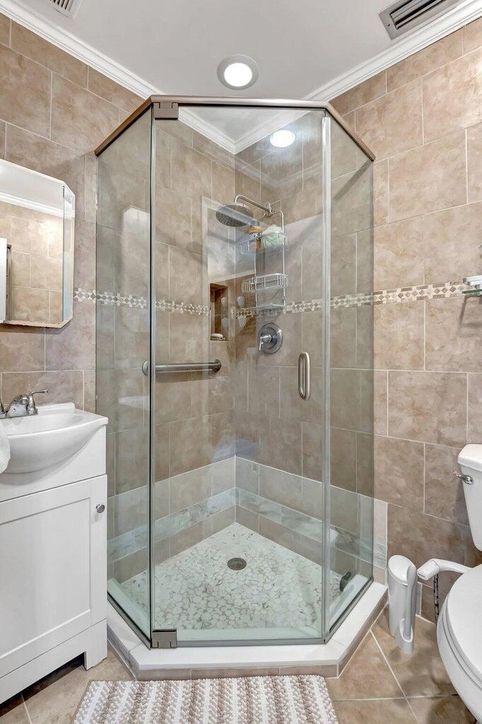 1710 Northwest 18th Avenue, Unit 204 Delray Beach, FL 33445 - Photo 12 of 21 a bathroom with a shower a toilet and sink
