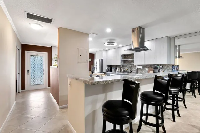 a kitchen with cabinets a sink and chairs
