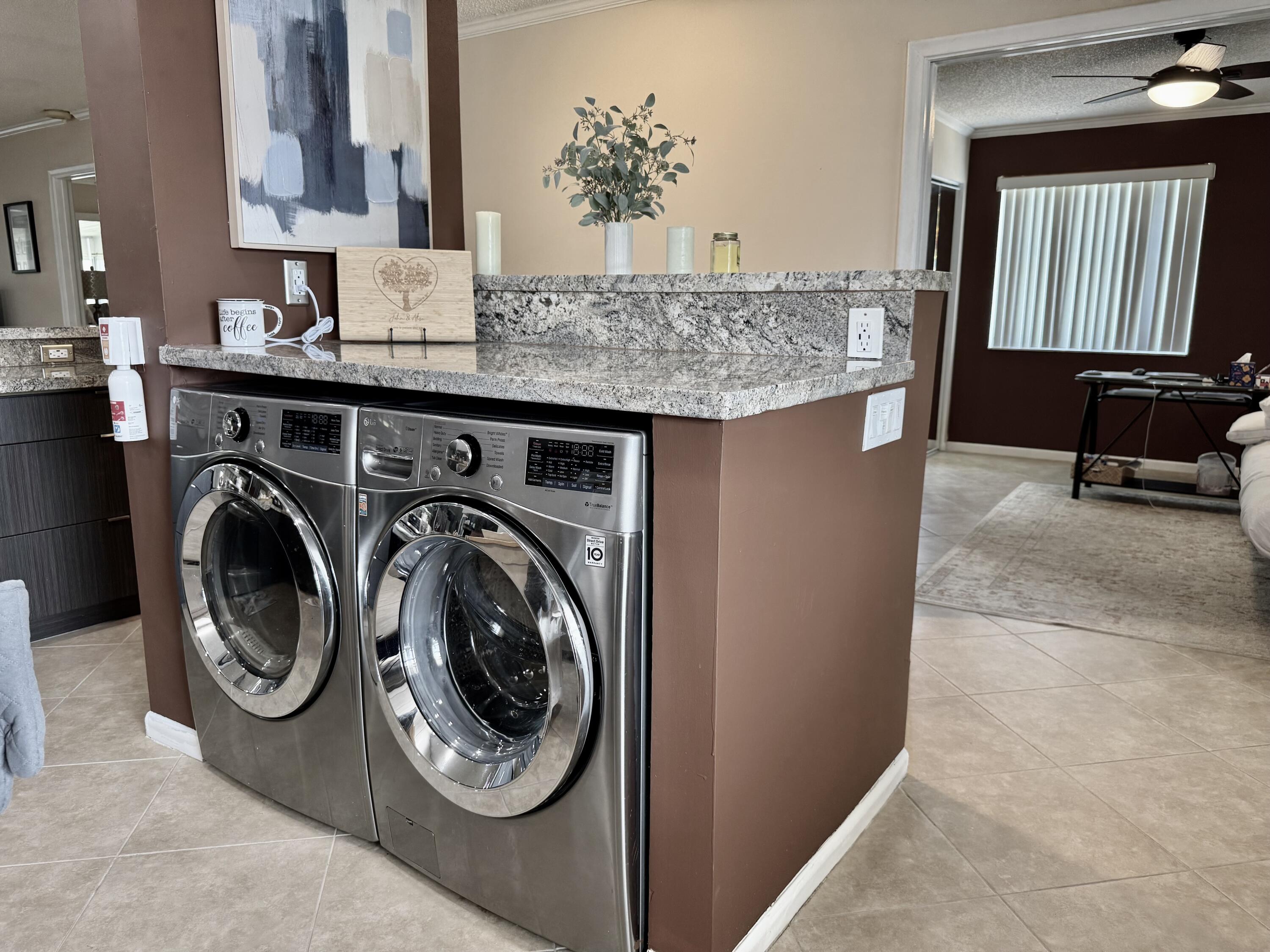 1710 Northwest 18th Avenue, Unit 204 Delray Beach, FL 33445 - Photo 7 of 21 a utility room with kitchen island a sink washer and dryer