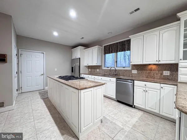 a kitchen with stainless steel appliances granite countertop a stove and a refrigerator
