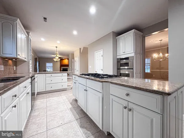 a large kitchen with stainless steel appliances lots of counter space and a sink
