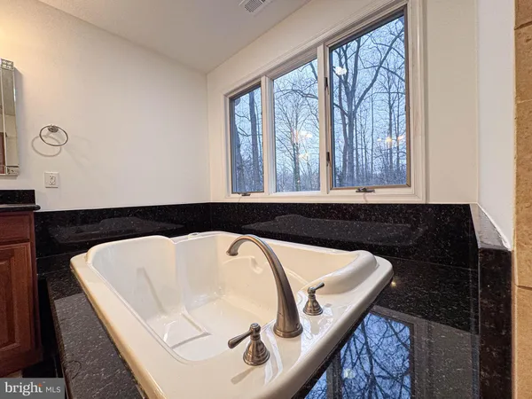 an empty room with wooden floor & cabinet and windows
