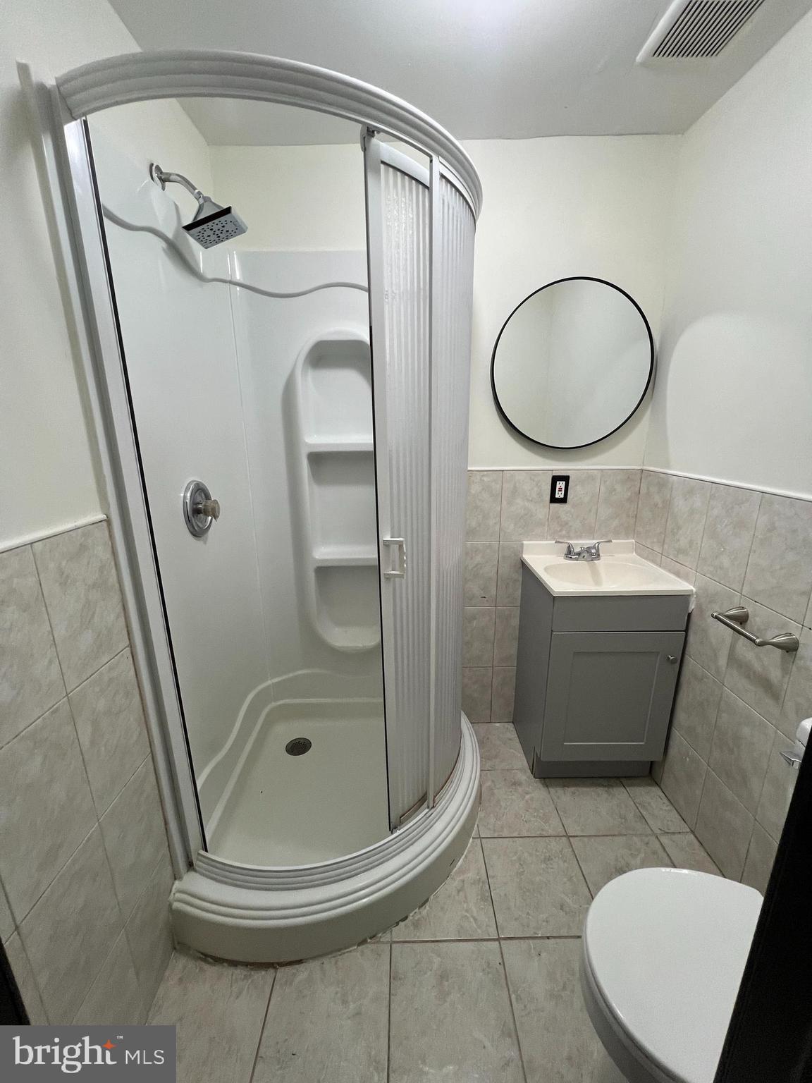 434 Birch Street Reading, PA 19604 - Photo 15 of 21 a bathroom with a sink a mirror a toilet and a glass door shower
