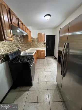 a kitchen with stainless steel appliances granite countertop a refrigerator and a stove