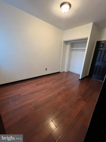 an empty room with wooden floor and closet