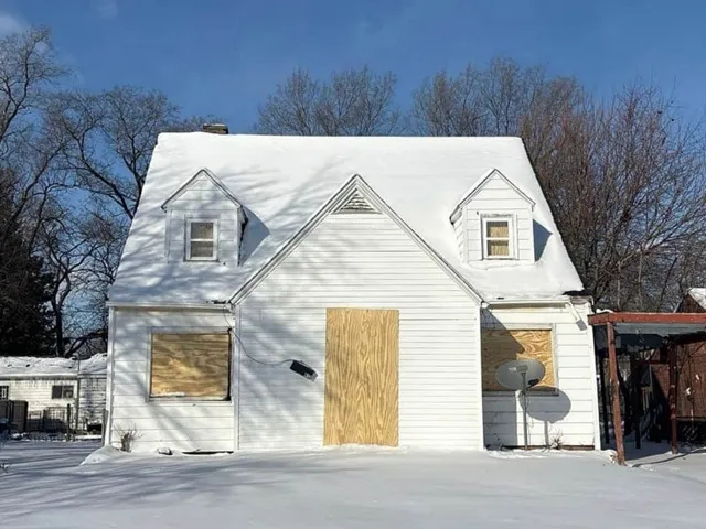 a view of a white house with large windows and a small yard