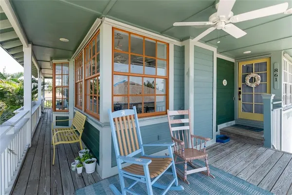 a porch area with table and chairs