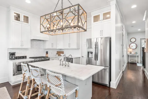 a kitchen with stainless steel appliances a table chairs and a refrigerator