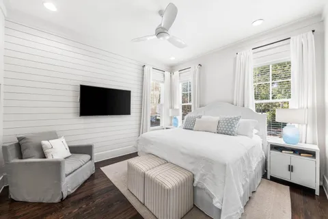 a bedroom with a large bed a flat tv screen and a couch