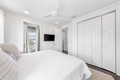 a bedroom with a large bed and a flat tv screen