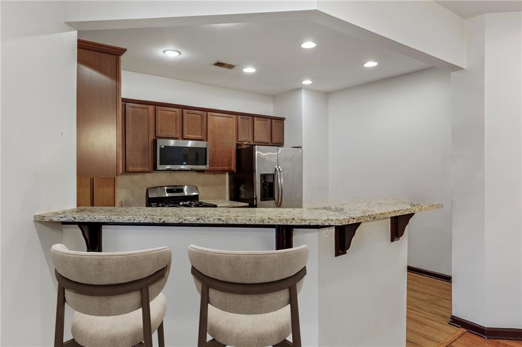 4430 Cedar Bridge Walk Suwanee, GA 30024 - Photo 14 of 33 a kitchen with granite countertop kitchen island stainless steel appliances a sink and a refrigerator